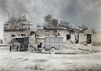 Två ambulansfordon framför en byggnad som har ödelagts av artillerield, Belgien, 17 september 1917 (autokrom)